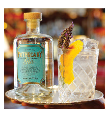 picture of a bottle of Pothecary Gin next to a glass with orange garnish on a metal tray