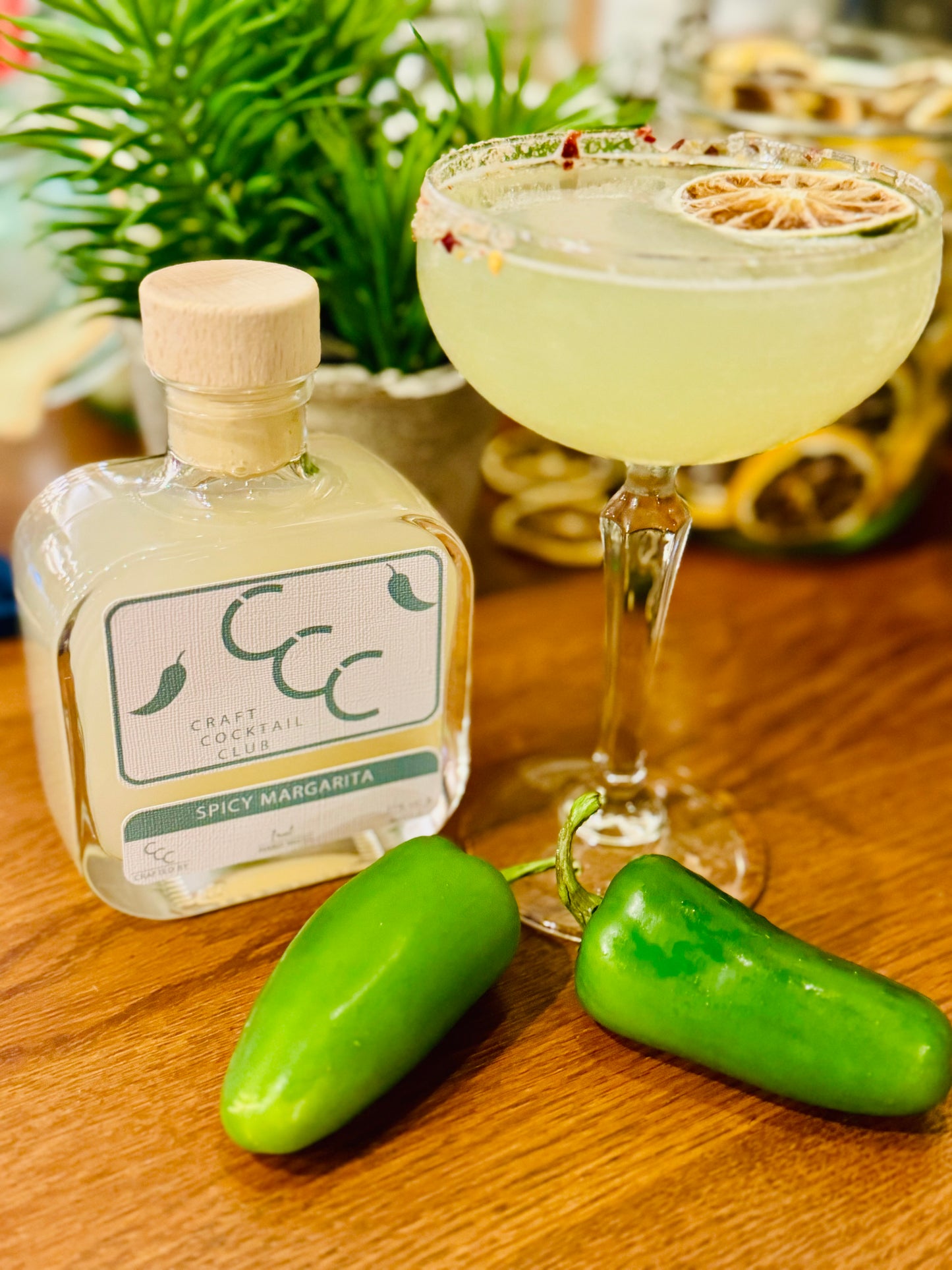 picture of a spicy margarita glass with a spicy salt rim with chillis around the base of the glass