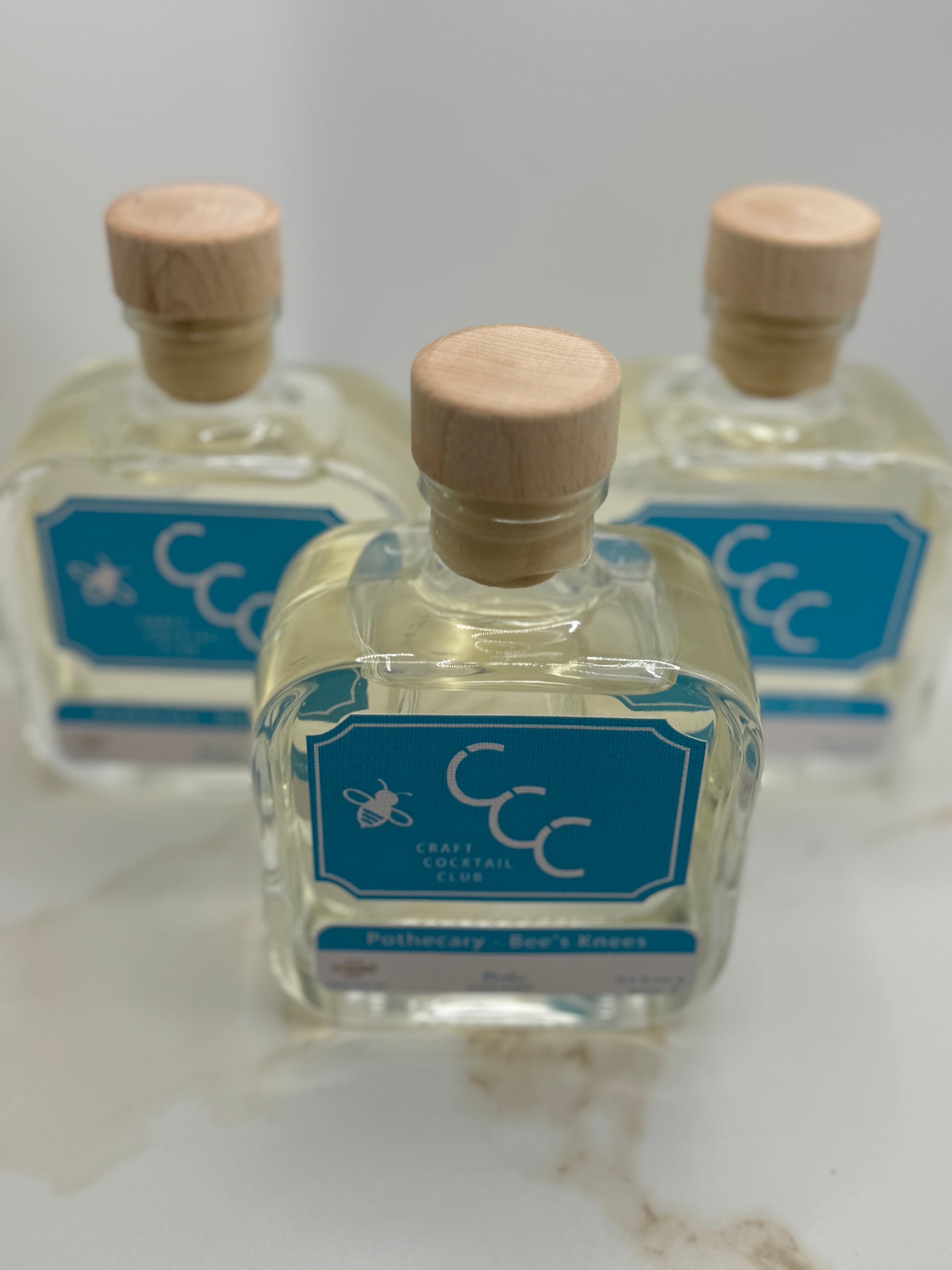 product picture of three bottles with a straw coloured liquid and a blue label 