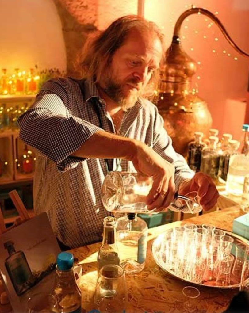 picture of Martin from pothcary gin pouring a gin with a copper still and fairy lights in the background 
