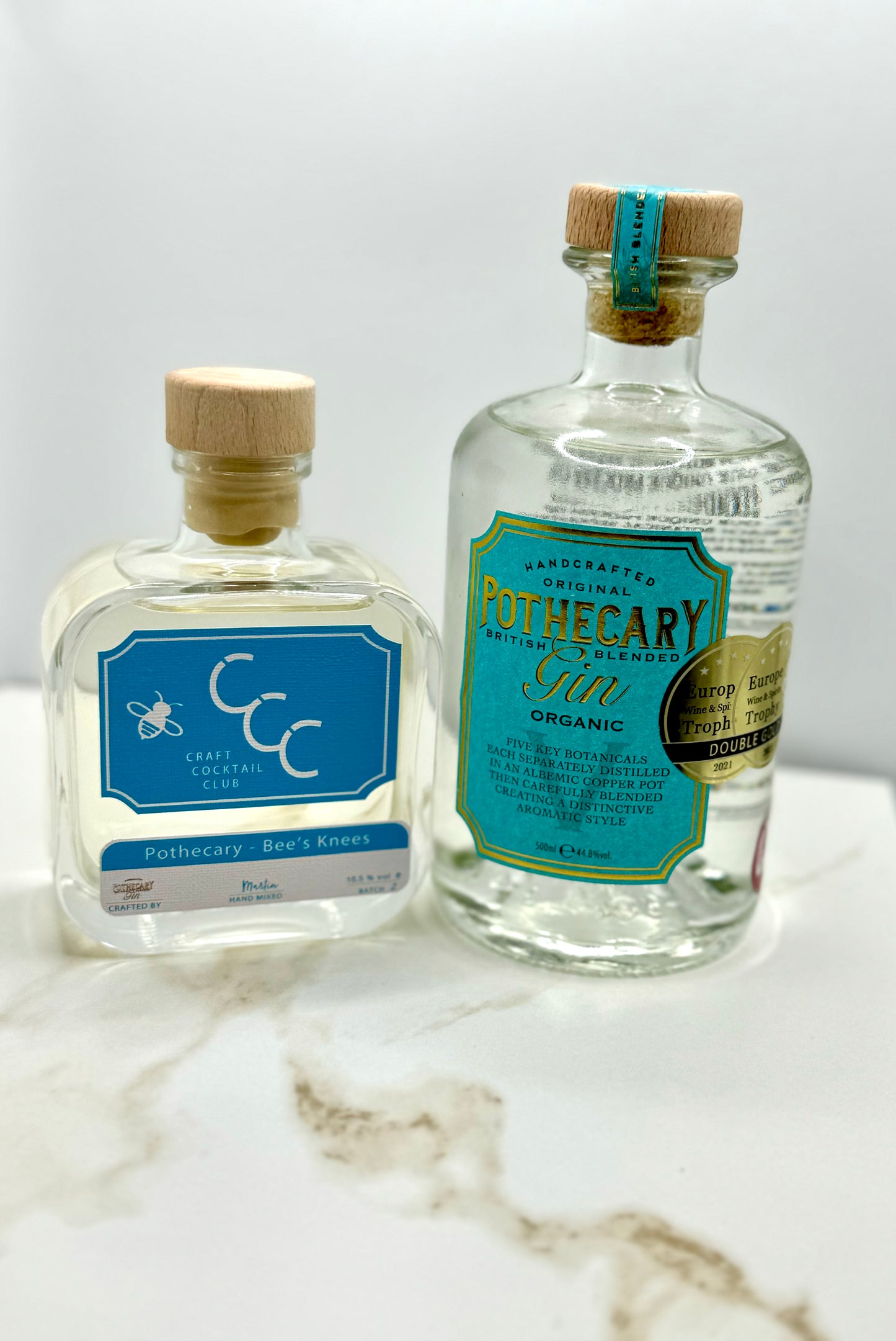 picture  of two bottles of gin in a Photo Booth on a cream and bronze tile  