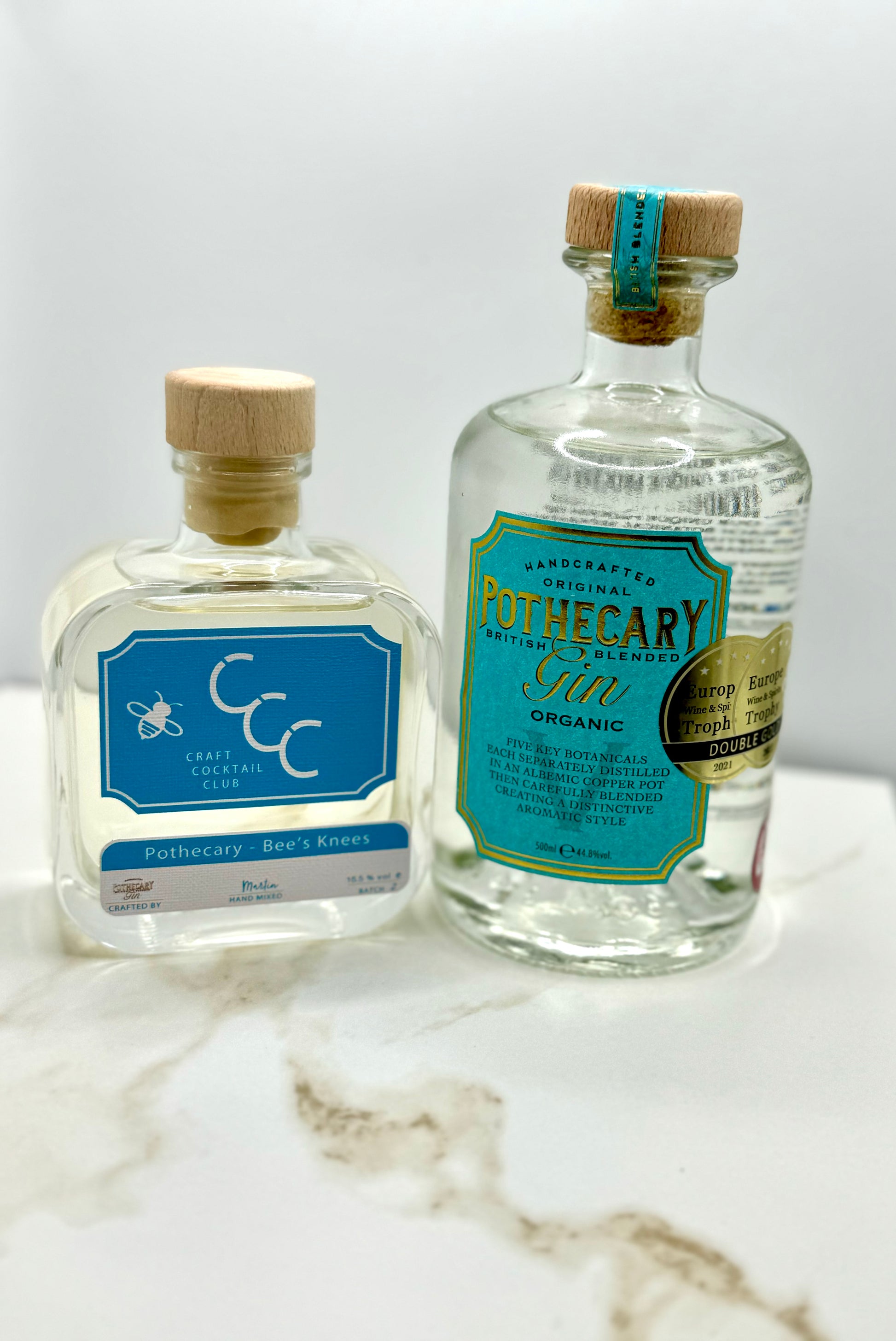 picture  of two bottles of gin in a Photo Booth on a cream and bronze tile  
