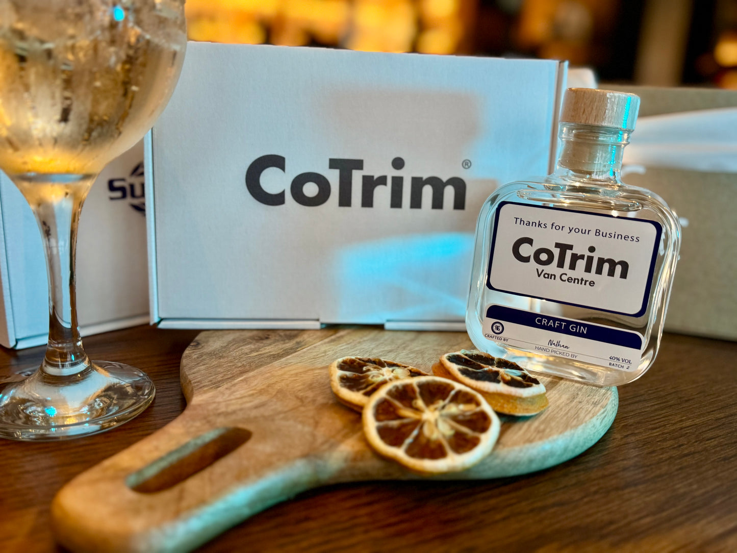 CoTrim bottle on a wooden board with a glass of gin  and branded box in the background